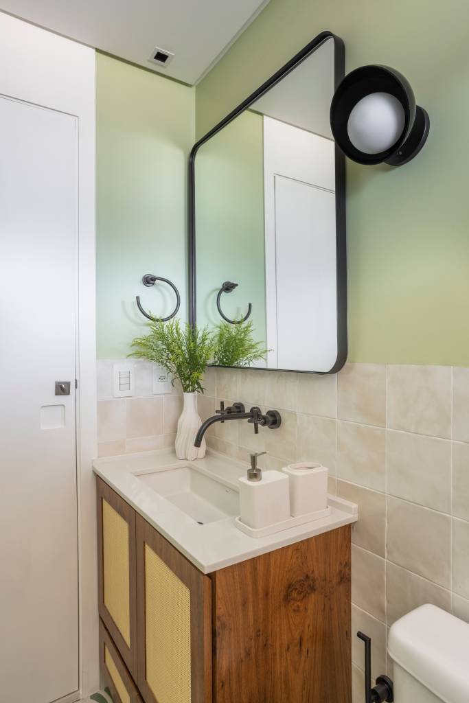 Reforma transforma quarto em home office e o integra a sala com porta de correr verde. Projeto de Adriana Favaro Arquitetura. Na foto,