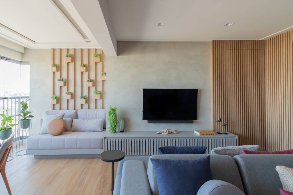 apartamento-87-m-adega-150-garrafas-marcenaria-azul-dz-studio-06-sala-jardim-vertical Apartamento de 87 m² ganha adega para 150 garrafas em marcenaria azul. Projeto de DZ Studio. Na foto, varanda, tv, jardim vertical, rack, sofá.
