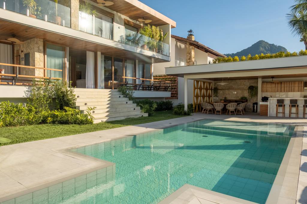 Linda casa de 800 m² tem área gourmet, piscina, sauna e terraço para contemplar o mar. Projeto de Viviane Cunha. Na foto, fachada, piscina.