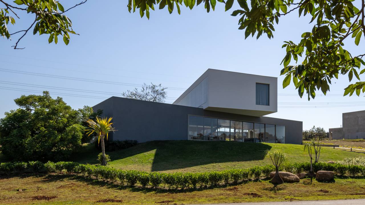 Dois volumes sobrepostos criam casa integrada com a paisagem e com o Sol. Projeto de HUM Arquitetos.