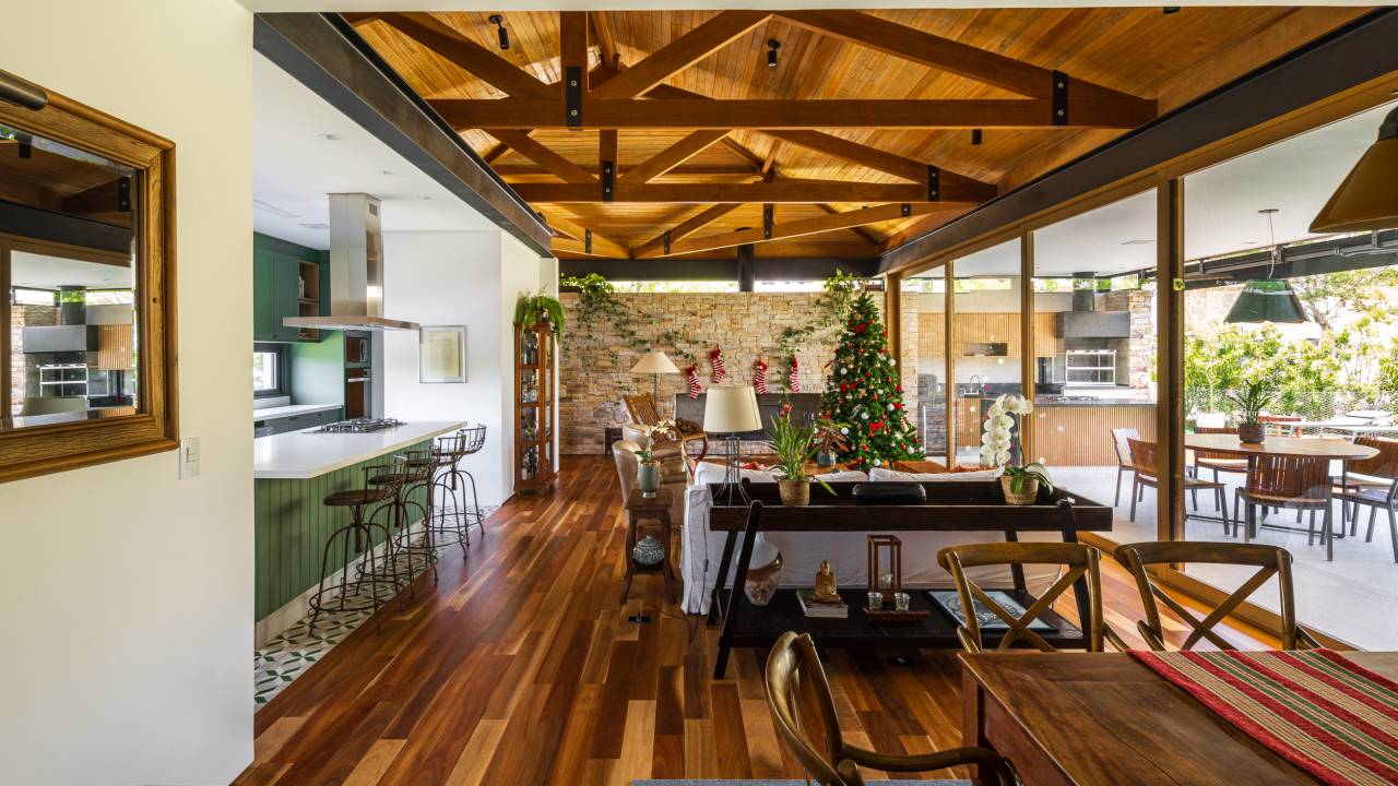 Projeto de casa supera o declive de 5 m do terreno e cria decoração rústica. Projeto de Sabella Arquitetura. Na foto, sala de estar em estilo rústico.