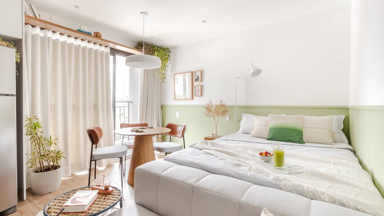 Você sabe o que exatamente é a decoração Aesthetic? Projeto de Rawi Arquitetura + Design. Na foto, quarto, meia parede verde clara, mesa redonda pequena.