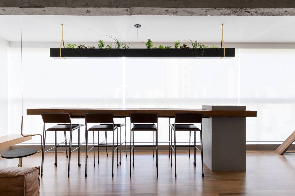 Hall de entrada revestido com muxarabis iluminados são destaque em apartamento. Projeto de Zalc Arquitetura. Na foto, varanda, sala de jantar.