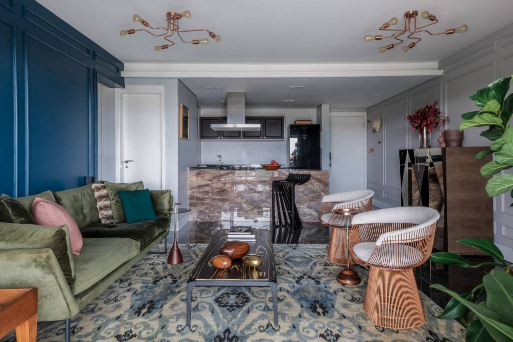 Parede azul com boiseries traz personalidade para apê que mistura estilos. Projeto de Ricardo Abreu Arquitetos.