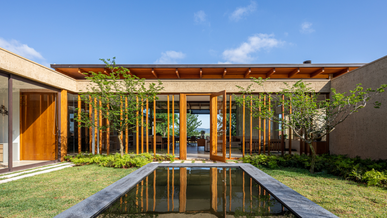 Vidro e brises de madeira conectam casa com 7 suítes com a natureza. Projeto de Gilda Meirelles Arquitetura