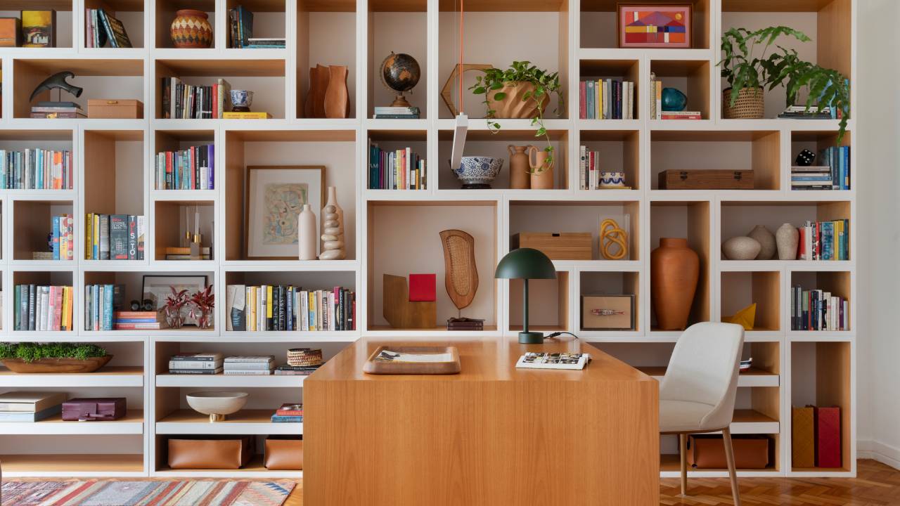 Biblioteca em casa: apê de 200 m² ganha espaço integrado para leitura. Projeto de Maria Juliana Galvão e Alexia Carvalho. Na foto, estante cheia de nichos.