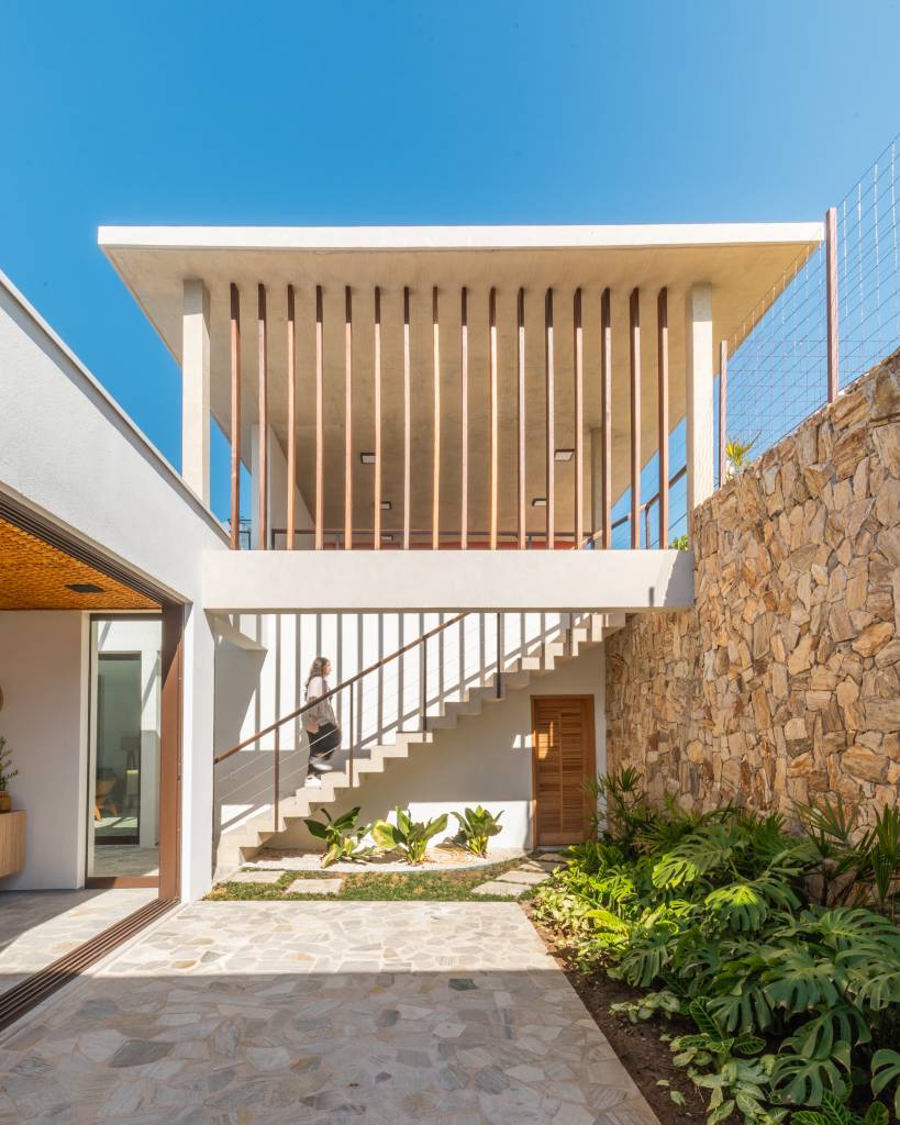 Casa de condomínio ganha salão de jogos, estúdio de música e quadra de areia. Projeto de Carolina Penna Arquitetos.