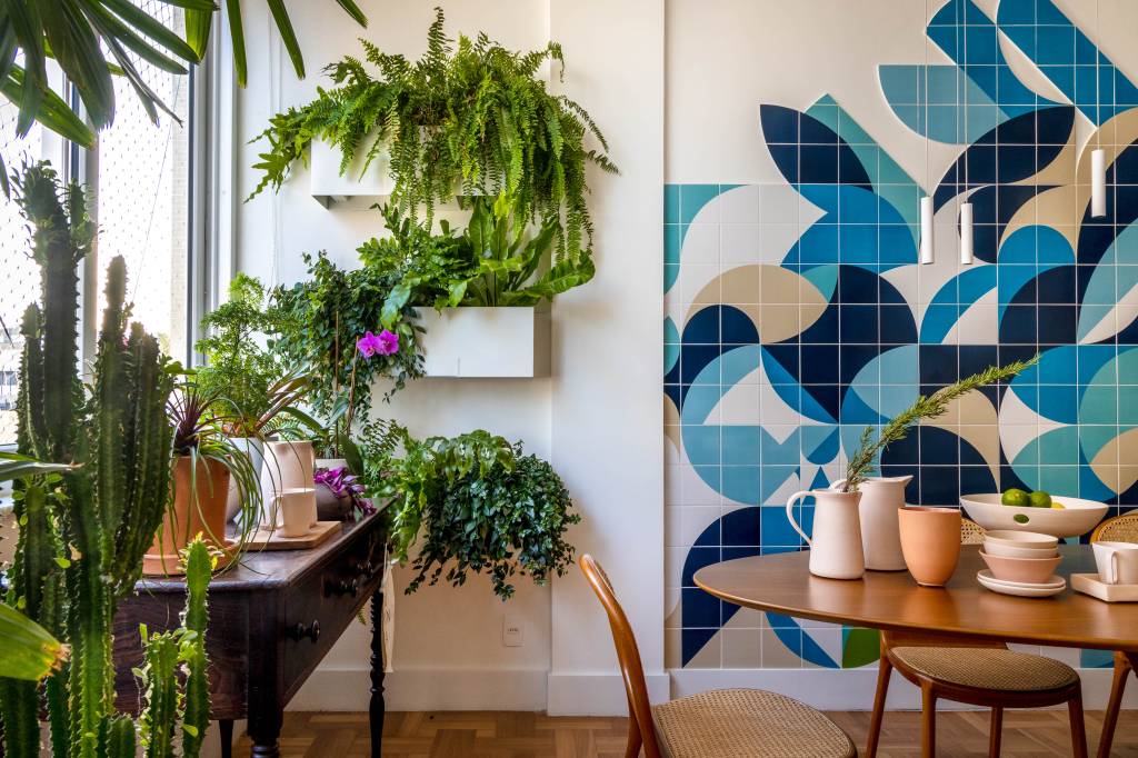 Plantas, azulejos e detalhes com temas marinhos dão charme à apê de 100 ². Projeto de Paula Neder. Na foto, sala, jardineiras suspensas.