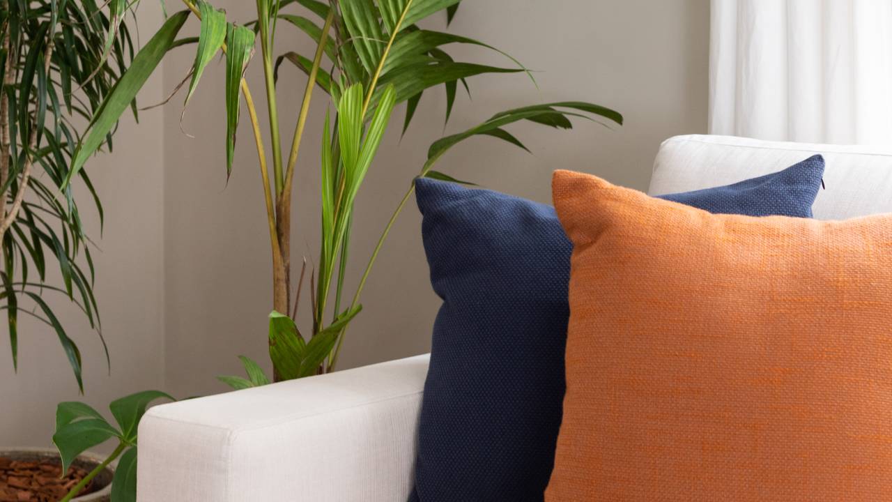 3 dicas fundamentais para incluir almofadas no décor. Projeto de Daniela Funari. Na foto, sofá com almofadas laranjas e azuis.