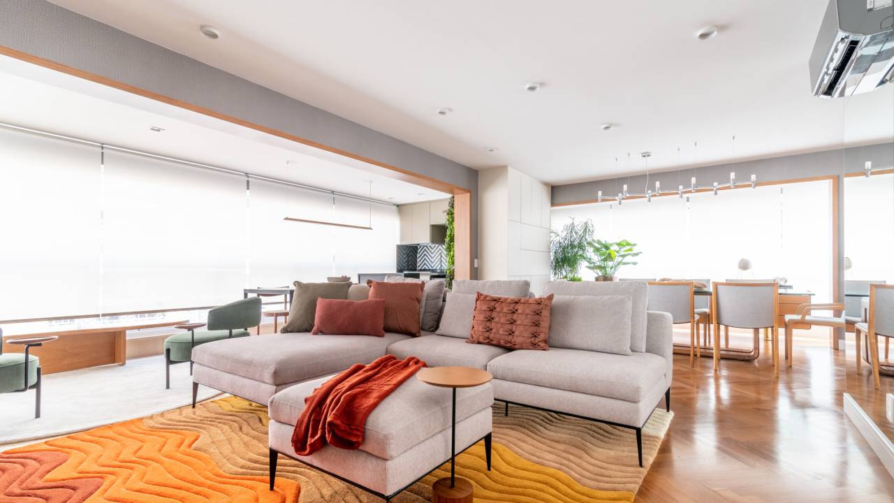 Apê de 142 m² recebe reforma sem mudanças estruturais. Projeto de Sabrina Salles. Na foto, sala de estar com sofá cinza e almofadas coloridas.