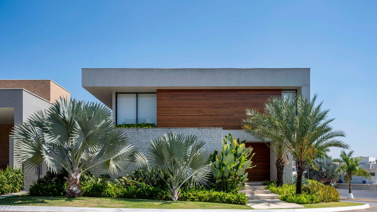 Paisagismo de casa de 860 m² conta com 31 espécies diferentes. No projeto Flávia D’Urso. Na foto, fachada de casa com jardim externo.