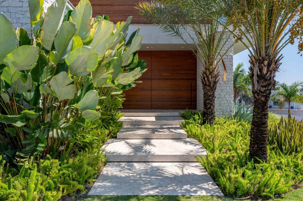 Paisagismo-de-casa-de-860-m2-conta-com-31-especies-diferentes-02 Paisagismo de casa de 860 m² conta com 31 espécies diferentes. No projeto Flávia D’Urso. Na foto, entrada de casa com jardim externo.