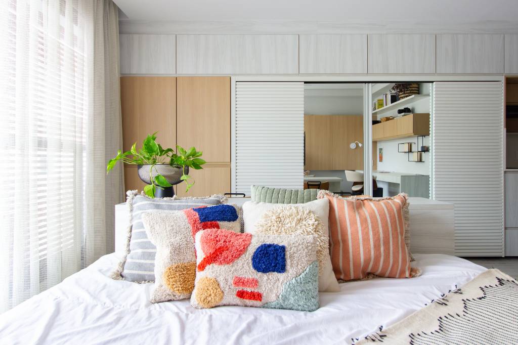 Cama central também é sofá neste apartamento compacto de 30 m². Projeto de Fernanda Olinto.