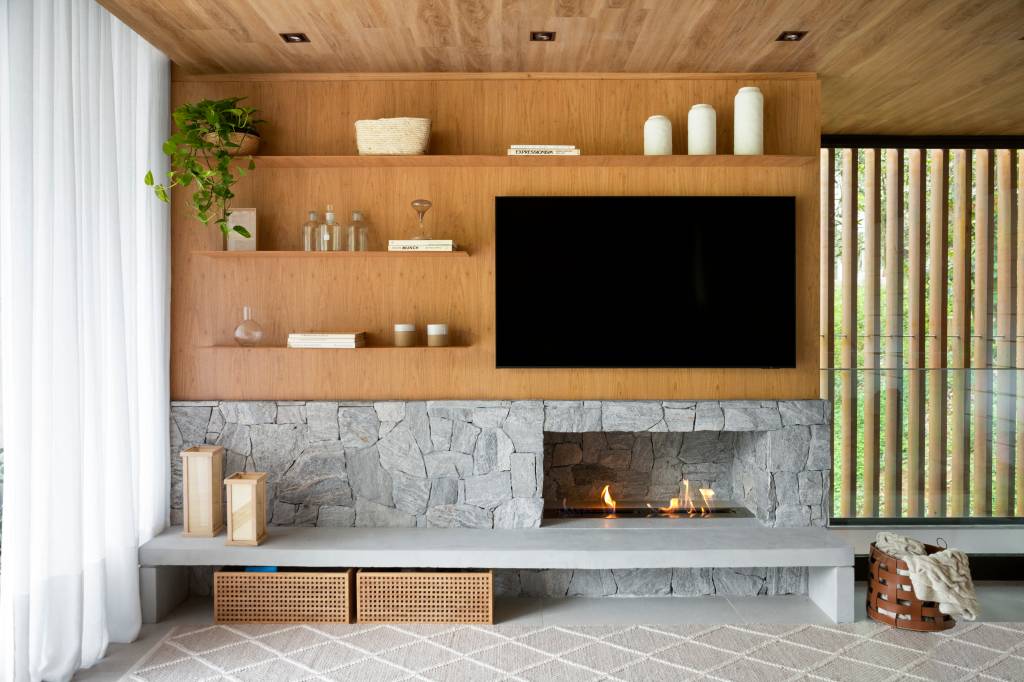 Casa de serra tem sala íntima que funciona como quarto de hóspedes. Projeto de Sabugosa Arquitetura. Living e TV.