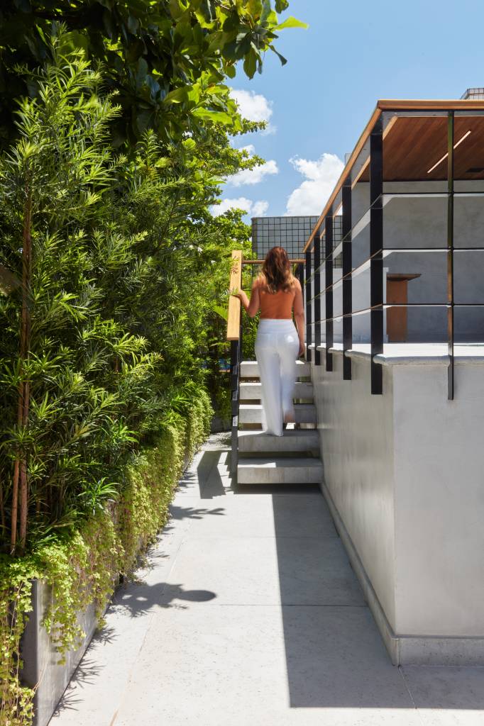 Cobertura tem móveis de madeira de demolição, jardim vertical e piscina em pedra Hijau. Projeto de Janeiro Arquitetura. Na foto, plantas, escada.
