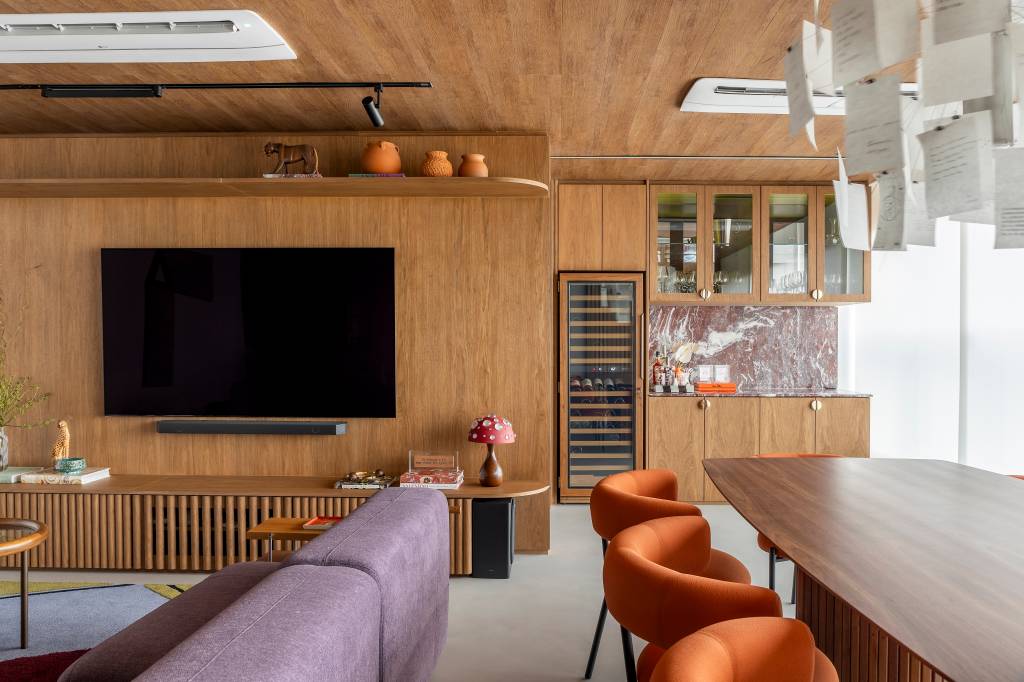 Revestimento vinílico em tom amadeirado traz unidade visual a apartamento de 145 m²