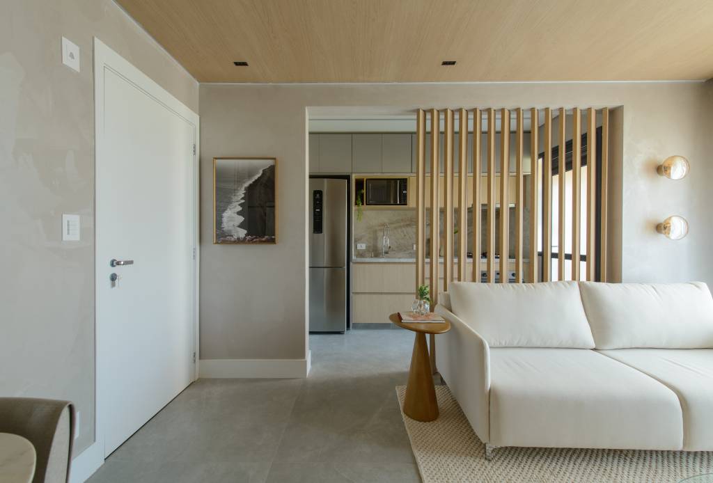 Apê de 56 m² em tons de bege tem divisória articulada entre sala e cozinha