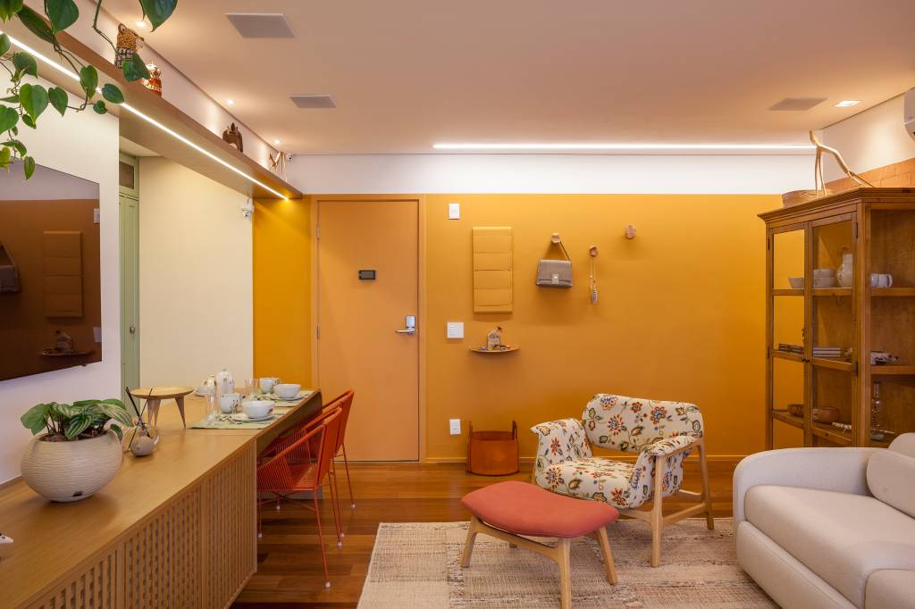 Paleta de cores vibrantes e brasilidade dão cara de casa à apê de 98 m². Projeto de Patrícia Viegas. Na foto, sala, poltrona estampada, parede amarela.