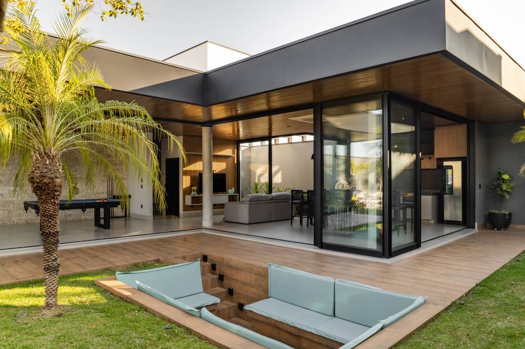Residência de 847 m² tem projeto contemporâneo voltado ao conforto e à convivencia. Projeto de Natália Sundfeld. Na foto: casa em estilo contemporâneo, lareira externa, área de lazer e convivência