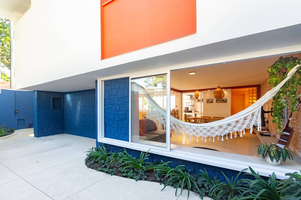 Casa com parede de tijolinhos e detalhes em cores primárias