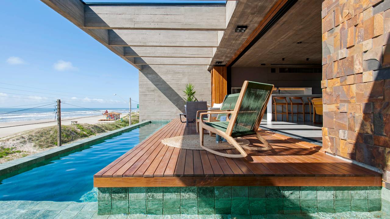Casa de 350 m² é um mirante com vista para o mar. Projeto de Mayresse Arquitetura. Na foto, varanda com piscina de borda infinita.