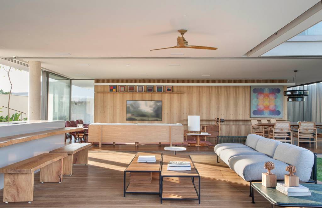 Brises verticais em chapa metálica perfurada regulam luz natural nesta casa. Projeto de Solange Calio Arquitetura.