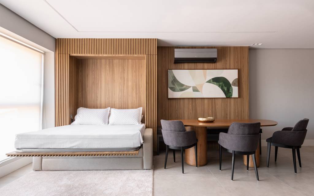 Cama embutida na parede faz sala de estar ser quarto neste apê de 89 m²