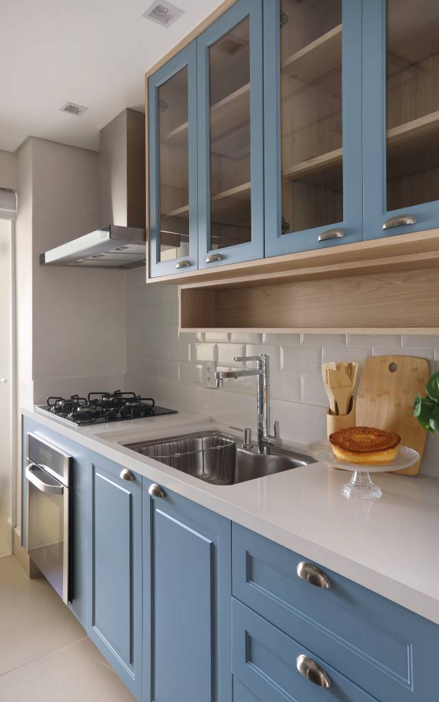 Armários em laca azul se destacam na cozinha deste apartamento. Projeto de RMV Interiores. Na foto, cozinha com armários azuis.