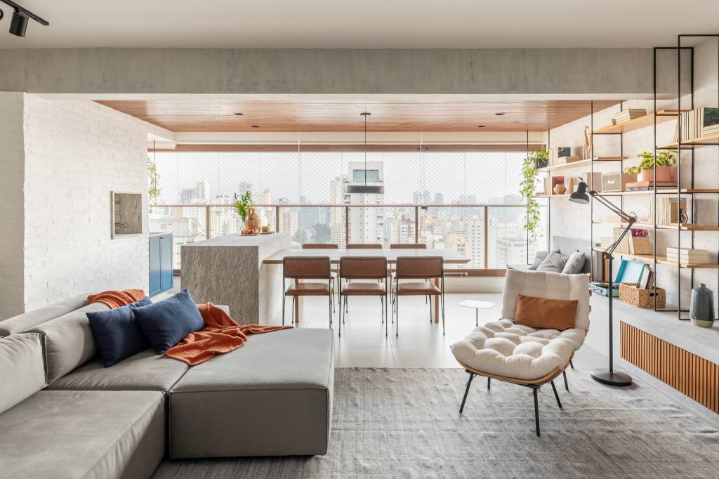 Apartamento integrado tem banco de concreto com futon na varanda