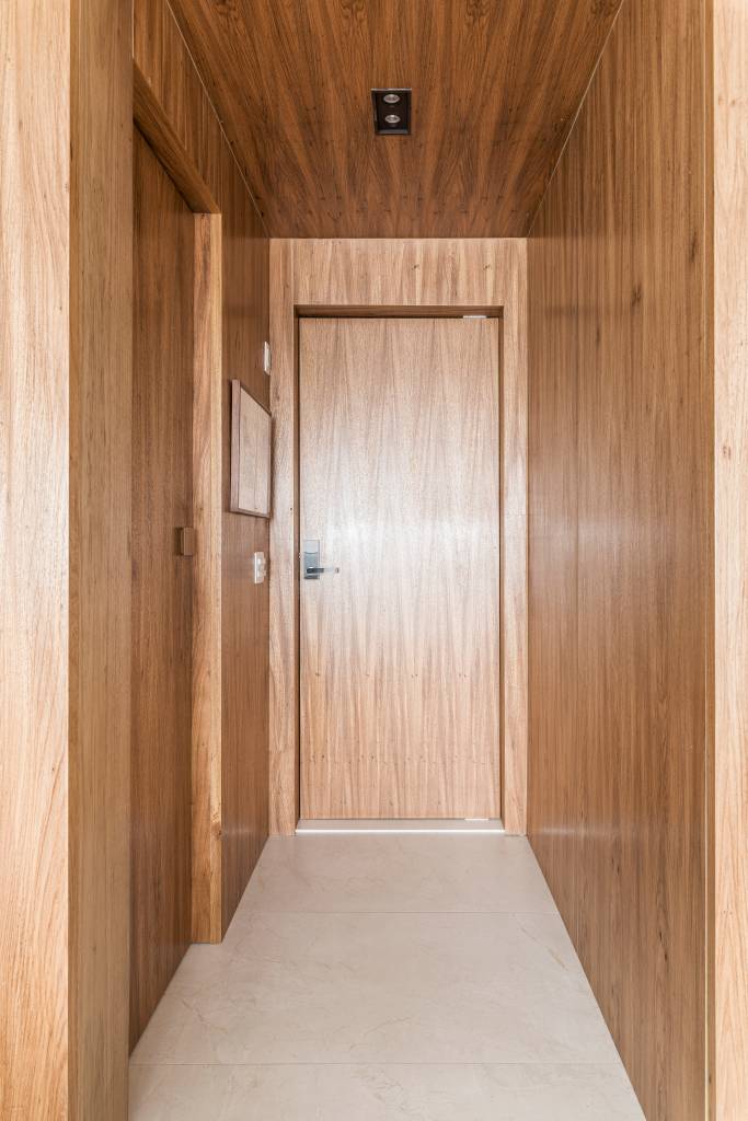 Detalhes em mármore e paredes com madeira freijó trazem elegância para este apê. Projeto de Vivi Cirello.