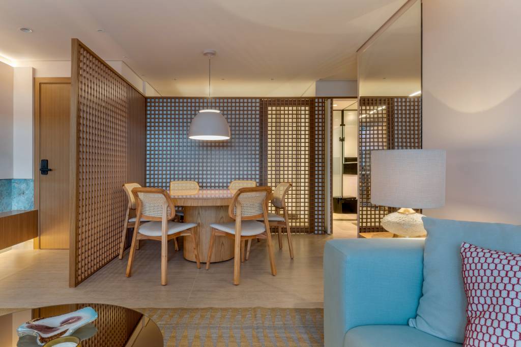 Painel de muxarabi esconde portas da cozinha e lavabo neste apartamento