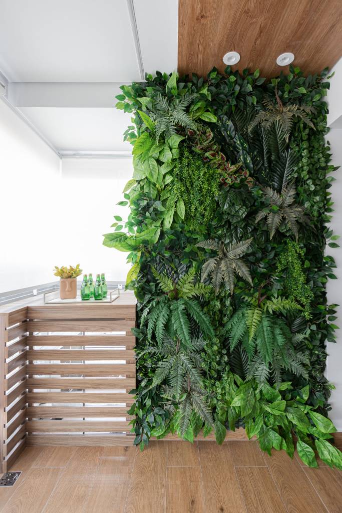Suíte de apartamento de 72 m² tem varandinha com jardim vertical. Projeto de RMV Interiores.