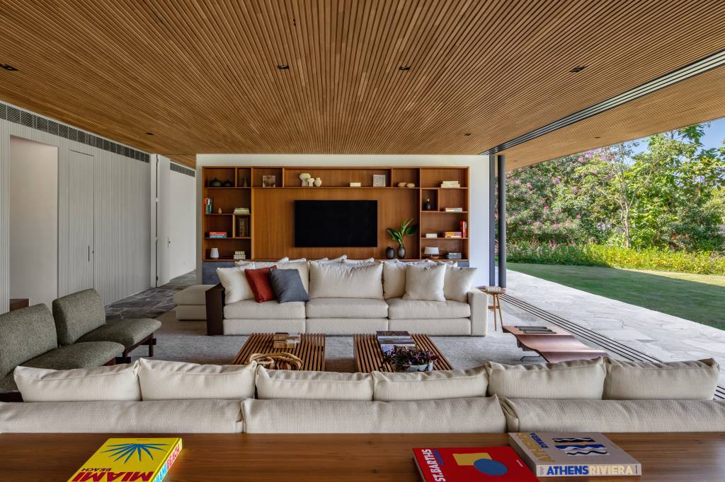 Casa-sustentavel-no-meio-do-mato-usou-brises-para-garantir-privacidade-Matheus-Farah-Manoel-Maia-Arquitetura-7 Casa sustentável no meio do mato usou brises para garantir privacidade. Projeto de Matheus Farah e Manoel Maia Arquitetura. Na foto, sala de estar integrada com varanda.