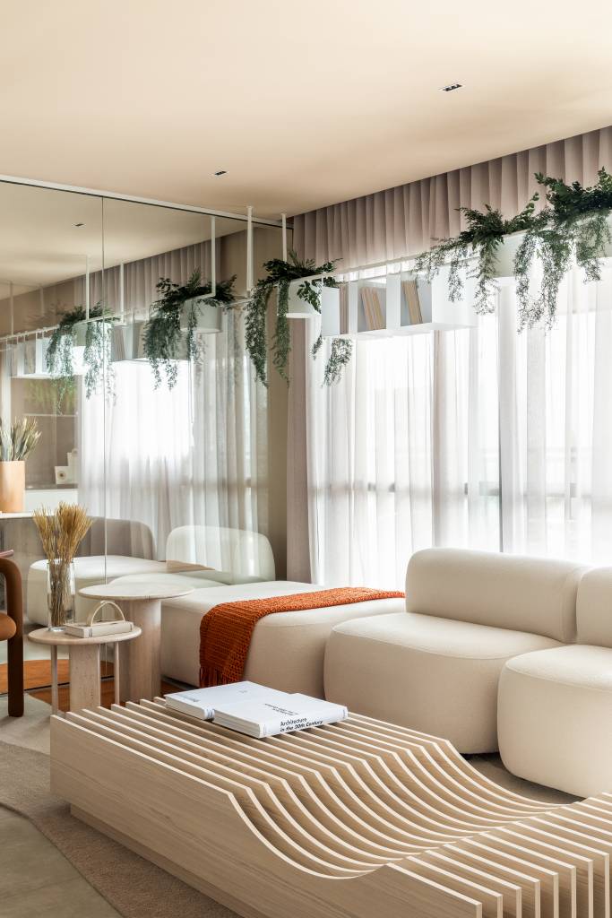 Apartamento tem prateleiras suspensas com jardineiras para plantas pendentes. Projeto de Bohrer Arquitetos.