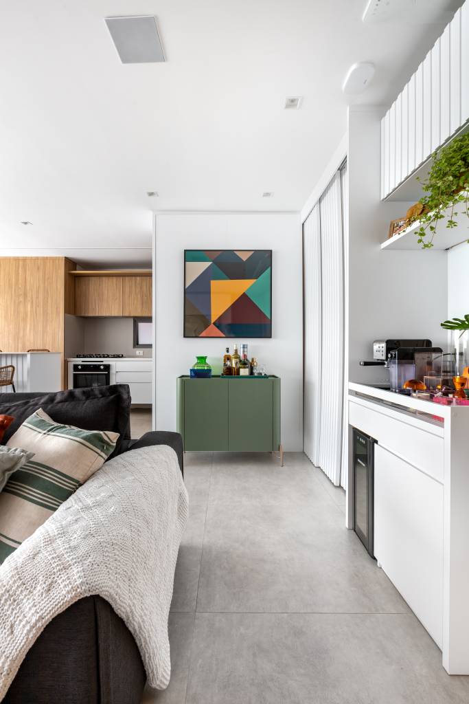 Apê com decoração leve ganha parede de tijolinhos na sala de TV. Projeto de Raquel Neves Arquitetura.