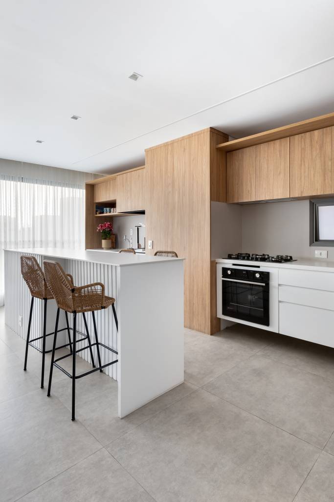 Apê com decoração leve ganha parede de tijolinhos na sala de TV. Projeto de Raquel Neves Arquitetura.