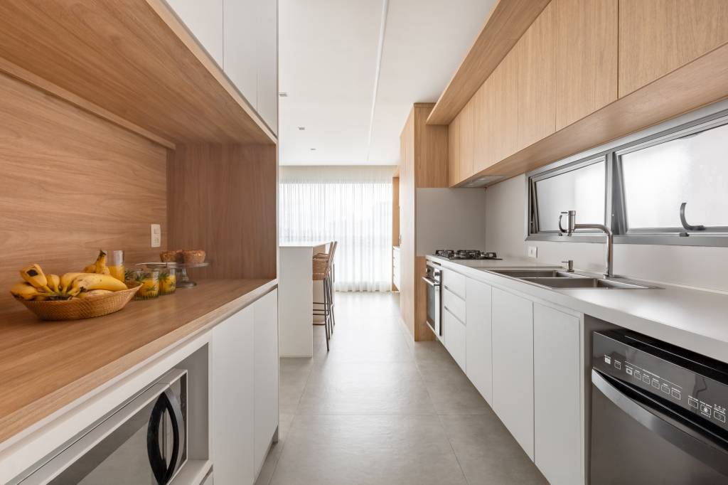 Apê com decoração leve ganha parede de tijolinhos na sala de TV. Projeto de Raquel Neves Arquitetura.
