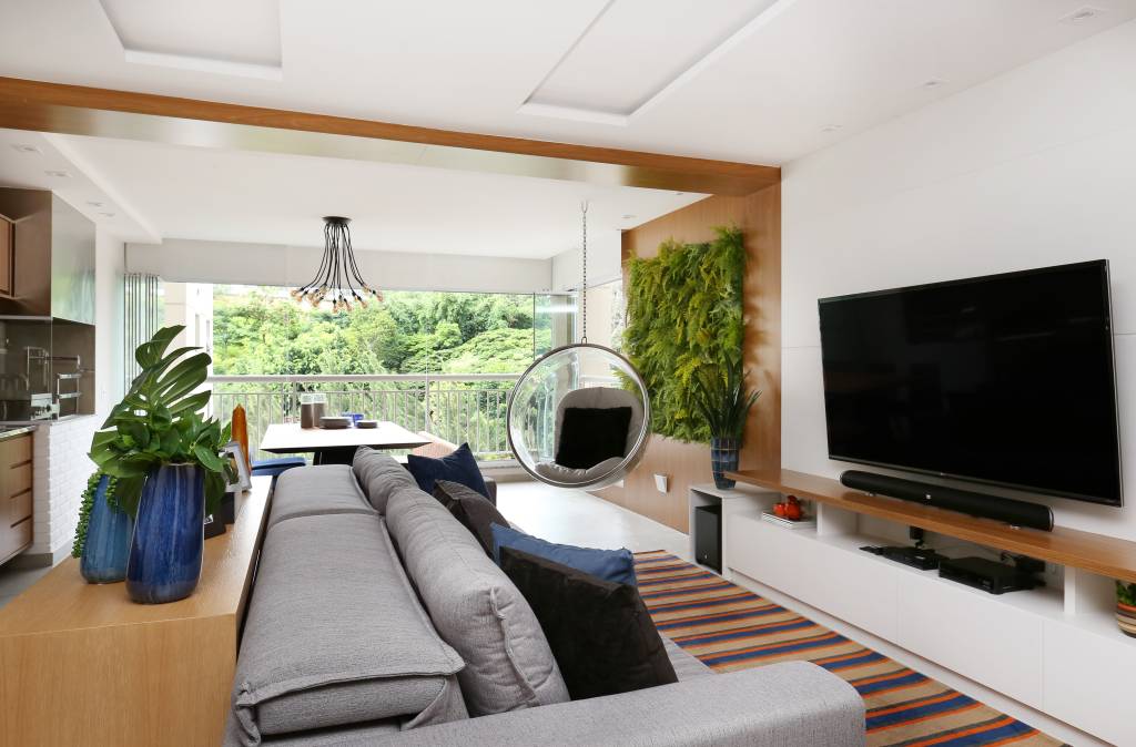 Apê contemporâneo de 90 m² tem balanço de acrílico na sala, jardim vertical e boiseries