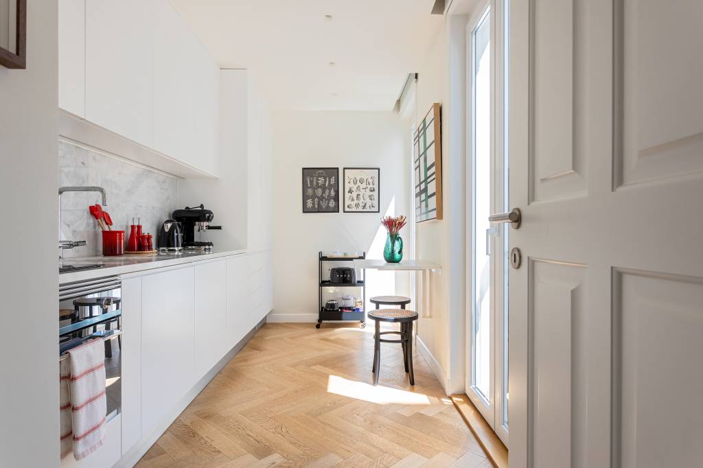 Boiseries e piso de madeira com paginação espinha de peixe dão elegância clássica a apê. Projeto de CW Arquitetura.