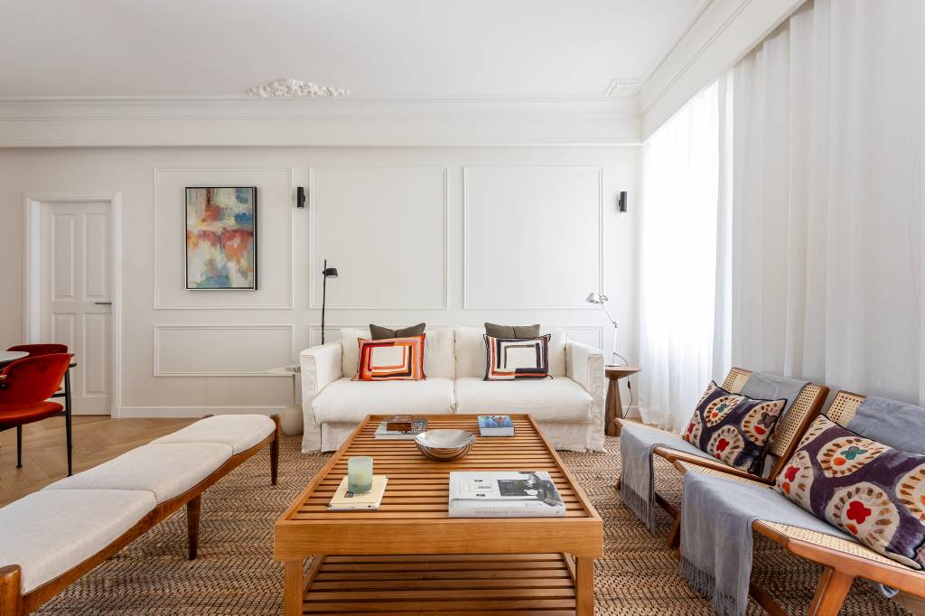 Boiseries e piso de madeira com paginação espinha de peixe dão elegância clássica a apê. Projeto de CW Arquitetura.