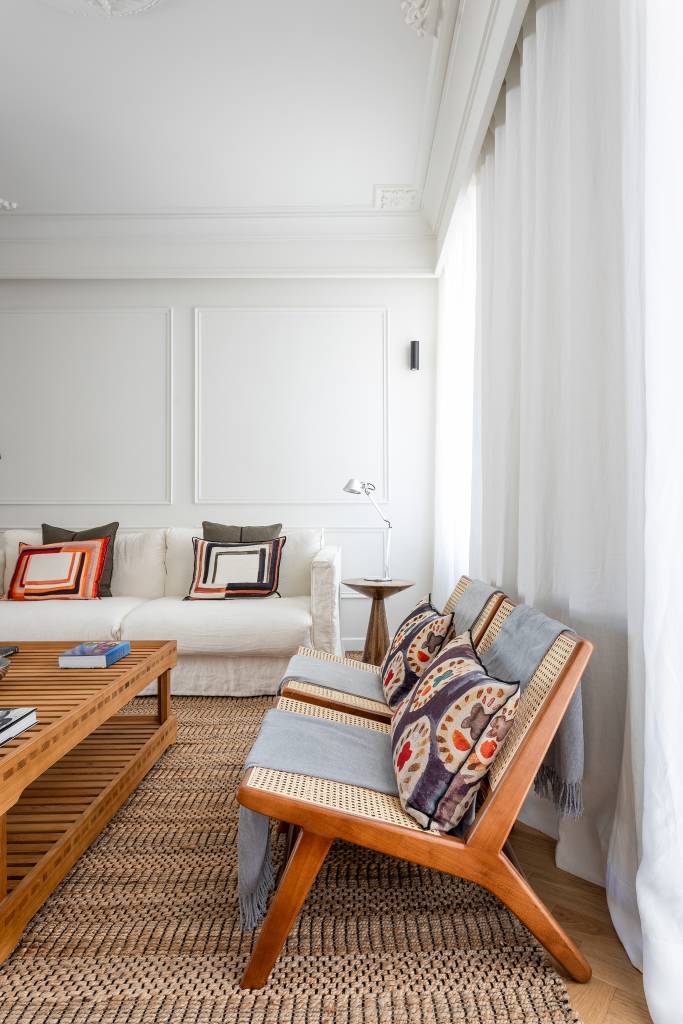 Boiseries e piso de madeira com paginação espinha de peixe dão elegância clássica a apê. Projeto de CW Arquitetura.