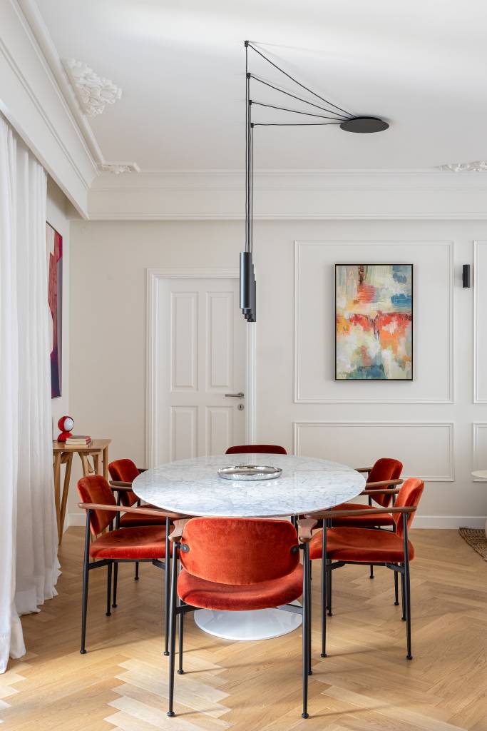 Boiseries e piso de madeira com paginação espinha de peixe dão elegância clássica a apê. Projeto de CW Arquitetura.