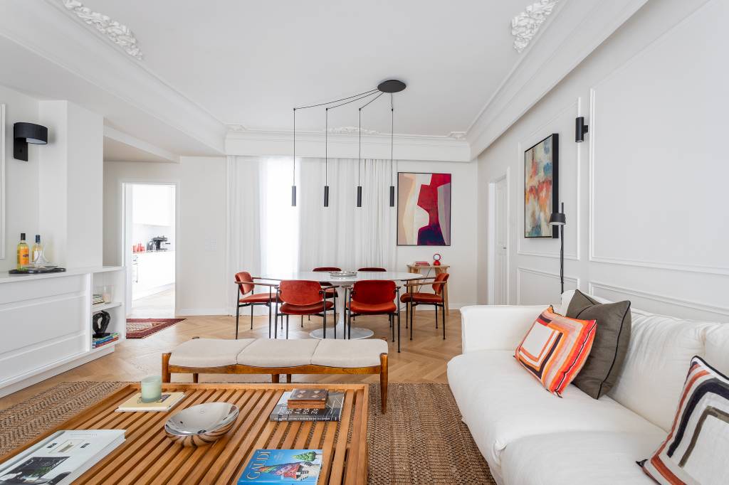 Boiseries e piso de madeira com paginação espinha de peixe dão elegância clássica a apê. Projeto de CW Arquitetura.