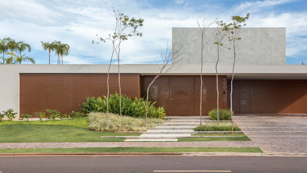 Casa 912 m² tem estrutura que une concreto, vigas metálicas e muxarabi em alumínio. Projeto de Solange Calio Arquitetos.