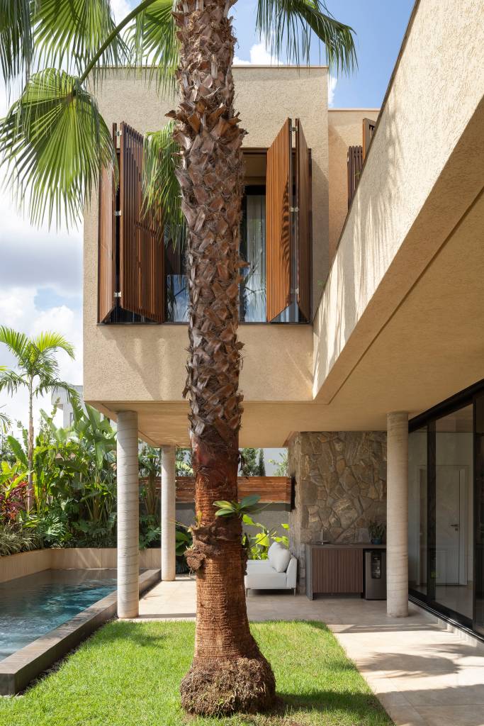 dois-blocos-sobrepostos-perpendiculares-formam-fachada-de-casa-elegante-wa-arquitetura-04-arvore-palmeira Dois blocos sobrepostos perpendiculares formam fachada de casa elegante. Projeto de WA Arquitetura.