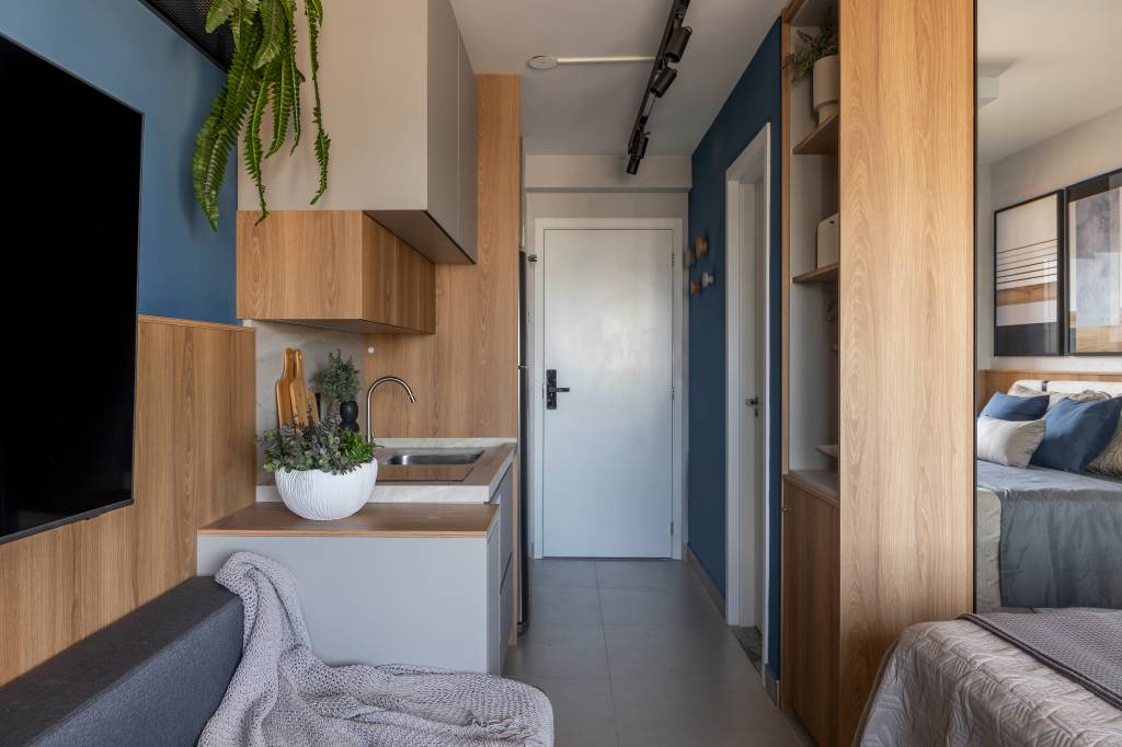 Estúdio funcional de 26 m² tem bancada para office e refeições na janela. Projeto de Art 2A Arquitetura.