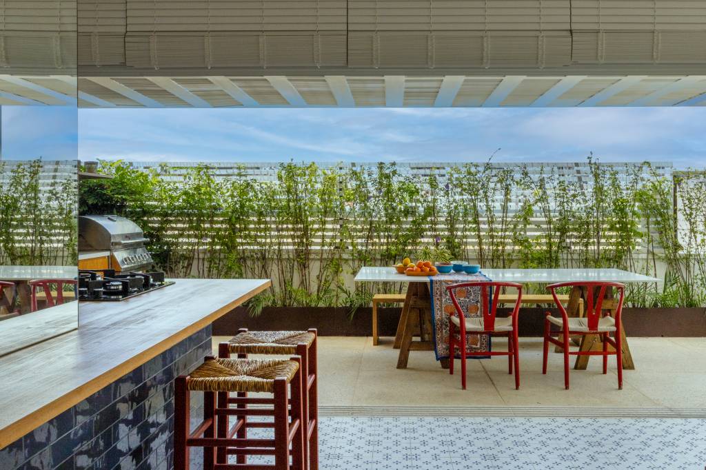 Jardins verticais, divisórias de alumínio e jardineiras trazem privacidade a terraço. Projeto de Migs Arquitetura com paisagismo de Anna Luiza Rothier.