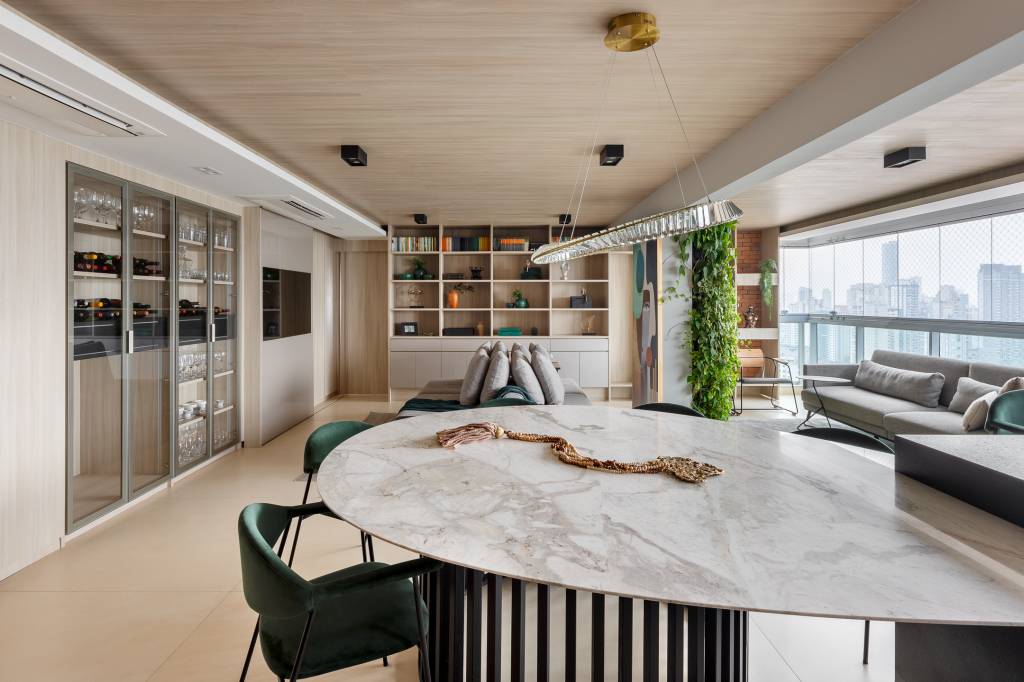 Mesa de jantar em formato orgânico com tampo de granito é destaque em apê