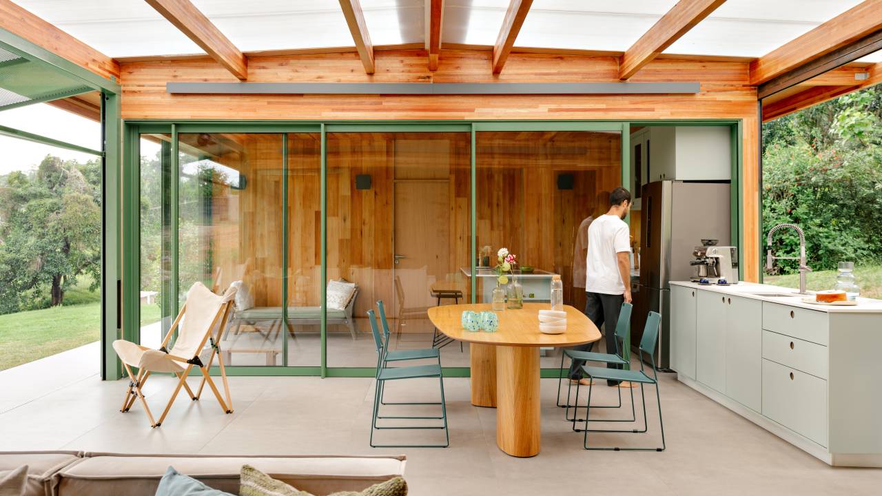 Varanda com telhas transparentes fica entre blocos de casa em CLT montada em 1 semana. Projeto de Nitsche Arquitetos.