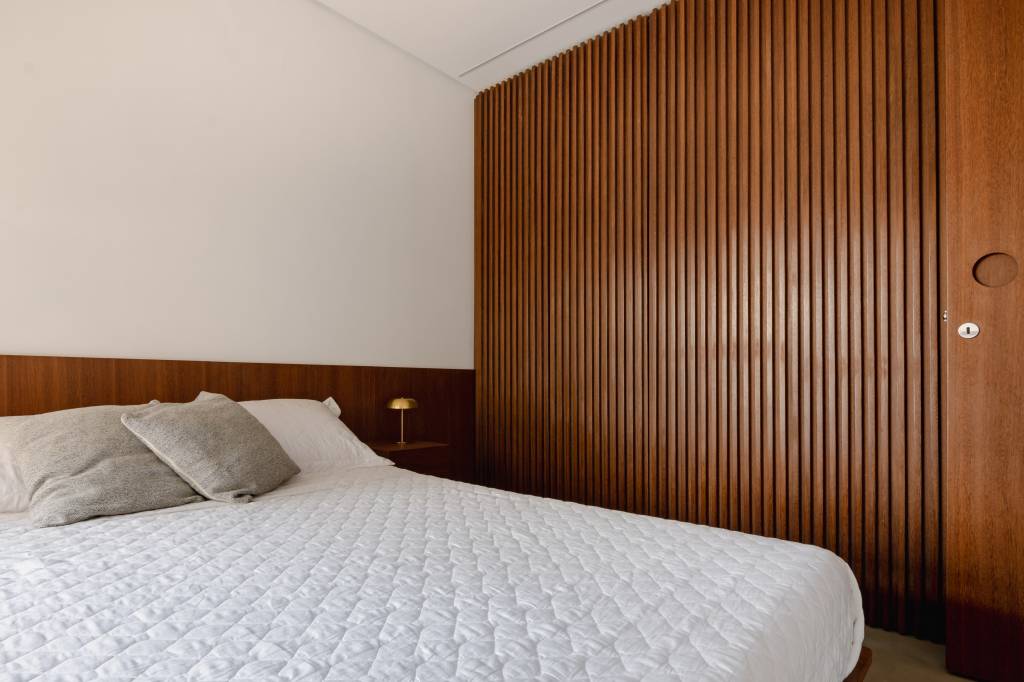 Apê pequeno tem home office verde e estiloso oculto na marcenaria. Projeto de COTA 760 Arquitetura.